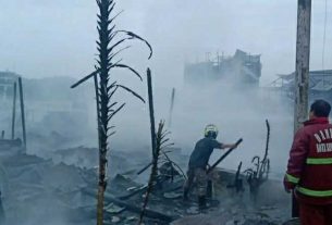 Seorang petugas Pemadam Kebakaran menyaksikan puing-puing sisa kebakaran yang masih berasap sesaat setelah Api berhasil dipadamkan. (foto : Exclusive)