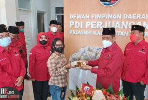 Ketua DPD PDI Perjuangan Kaltim Safaruddin menyerahkan potongan Tumpeng kepada salah seorang awak media yang hadir dalam HUT Ke-49 PDI Perjuangan. (foto : Lukman)