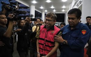 AHA, GM PT Antam Tbk tahun 2018 Tersangka korupsi. Meski tangan diborgol, ia masih tersenyum. (foto: Exclusive)