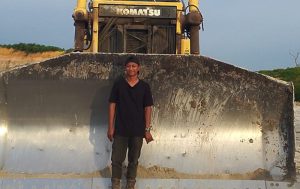 Yogi Novrian di depan Dozer yang dioperasikan selama bekerja di PT. MAS. (foto: Exclusive)