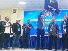 Akhmad Munir mengibarkan Bendera Pataka PWI Pusat setelah dinobatkan sebagai Ketua Umum PWI Pusat periode 2025–2030, usai meraih dukungan 52 suara mengalahkan jumlah perolehan suara Hendry Ch. Bangun yang hanya meraih 35 suara. (foto: Exclusive)
