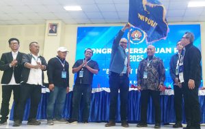 Akhmad Munir mengibarkan Bendera Pataka PWI Pusat setelah dinobatkan sebagai Ketua Umum PWI Pusat periode 2025–2030, usai meraih dukungan 52 suara mengalahkan jumlah perolehan suara Hendry Ch. Bangun yang hanya meraih 35 suara. (foto: Exclusive)