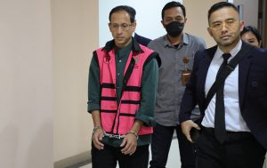Mengenakan rompi tahanan dan tangan diborgol, NAM digiring petugas Kejaksaan untuk dibawa ke Rutan menjalani penahanan setelah ditetapkan sebagai tersangka. (foto: Exclusive)
