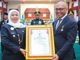 Gubernur Jawa Timur Khofifah Indar Parawansa menyerahkan Piagam Jer Basuki Mawa Beya kepada Ketum PWI Pusat Akhmad Munir. (foto: PWI Pusat)
