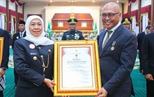 Gubernur Jawa Timur Khofifah Indar Parawansa menyerahkan Piagam Jer Basuki Mawa Beya kepada Ketum PWI Pusat Akhmad Munir. (foto: PWI Pusat)