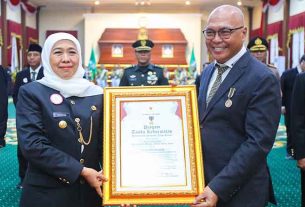 Gubernur Jawa Timur Khofifah Indar Parawansa menyerahkan Piagam Jer Basuki Mawa Beya kepada Ketum PWI Pusat Akhmad Munir. (foto: PWI Pusat)